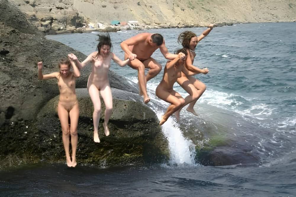 Mens and girls nudists on a beach - The practice of nudity within a community