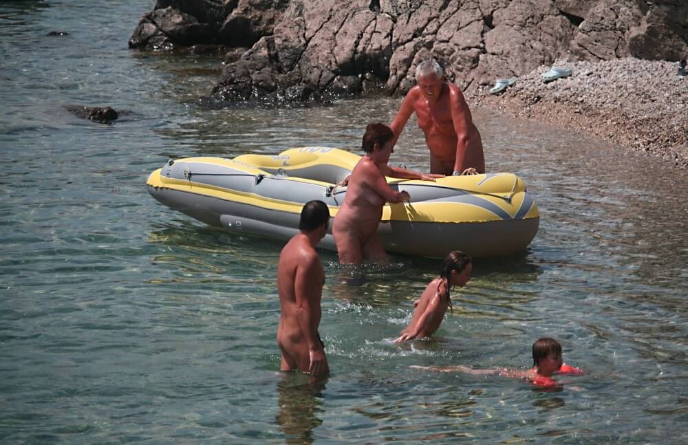 Lone Nudist in Yellow Boat photos - A defining feature of naturism is the absence of clothing